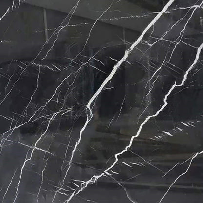 Bañera, encimeras y lavabos de mármol negro.